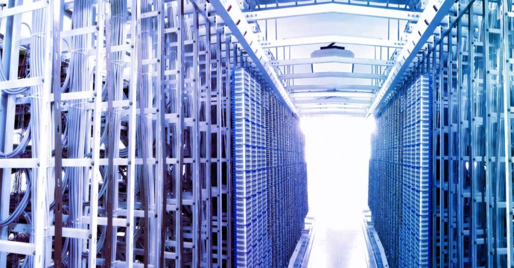data center server racks with bright light at the end of the corridor