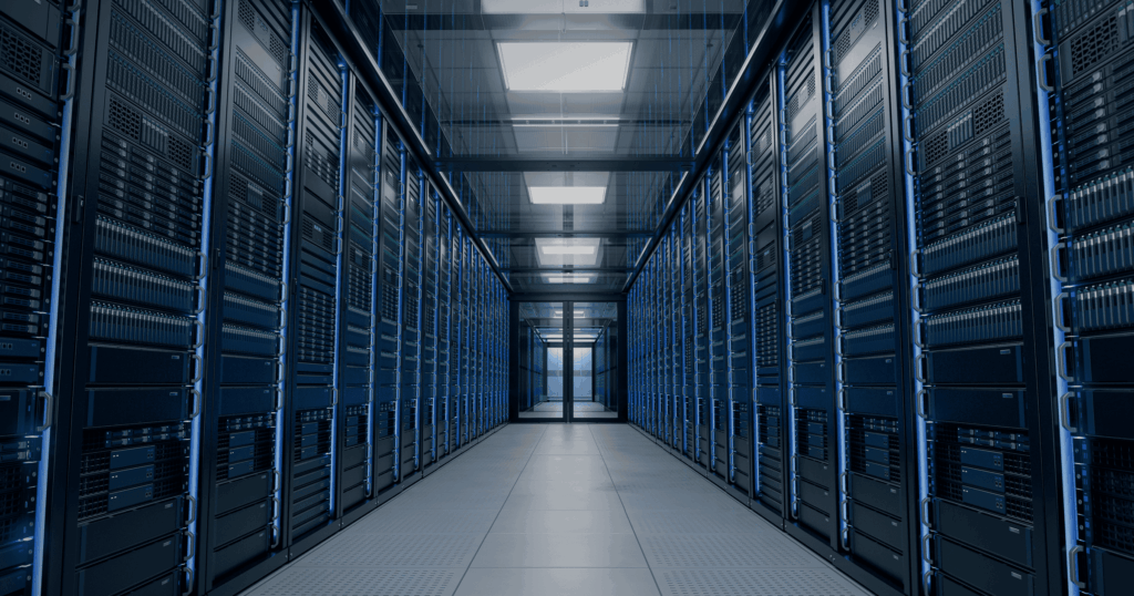 Rows of illuminated server racks lining a data center corridor that recedes toward a bright doorway, lit with blue accent lighting.