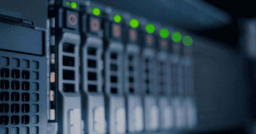 Close-up of a row of enterprise storage drives in a server enclosure, receding into shallow focus, with green status LEDs lit across the top and cool blue lighting.